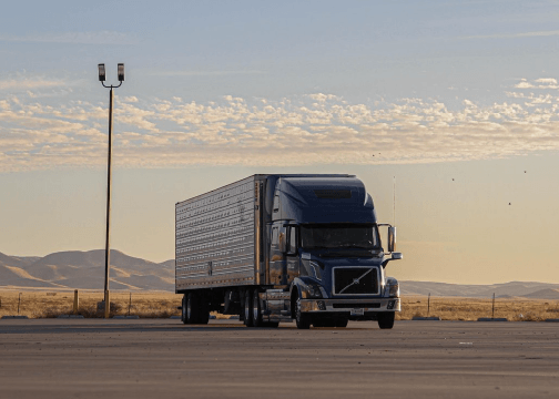 Un camión de carga estacionado en una carretera vacía al atardecer