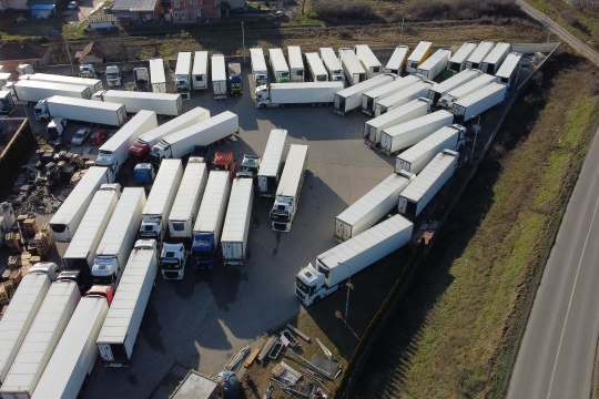 Illustration of an unorganized fleet with scattered trailers and trucks, representing inefficiency, lack of tracking, and poor trailer utilization in logistics operations.